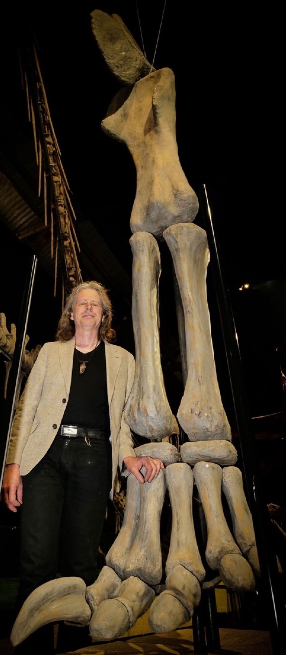 Roland vid det gigantiska frambenet till världens största Mamenchisaurus hos A World of Dinosaurs